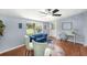 Bright living room boasts a blue sofa, wood flooring, and a ceiling fan at 6801 16Th N St, St Petersburg, FL 33702