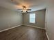 Bright bedroom with a ceiling fan, window, and wood-look flooring at 13344 Great Plains S Dr, Riverview, FL 33579