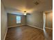 Spacious bedroom with wood-look flooring, ceiling fan, and natural light from a window at 13344 Great Plains S Dr, Riverview, FL 33579