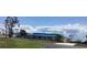 Exterior view of a single-story home with a blue tarp on the roof and a spacious front yard at 3360 Peace River Dr, Punta Gorda, FL 33983