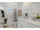 Well-lit bathroom with a modern vanity, white cabinets, and tiled shower with neutral accents at 5163 Arley Ct, North Port, FL 34288