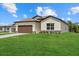 Beautiful single-story home featuring a well-manicured lawn and a two-car garage with brown doors at 5163 Arley Ct, North Port, FL 34288