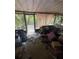 Sunroom showcasing natural light and potential, though showing signs of needed repairs and clutter at 8731 N 26Th St, Tampa, FL 33604