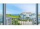 Scenic balcony view of a charming home with light blue siding, overlooking a lush green landscape and ocean at 283 Saint Lucia Dr # 202, Bradenton, FL 34209