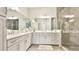 Bright bathroom featuring a double sink vanity, granite countertops, and glass enclosed shower at 283 Saint Lucia Dr # 202, Bradenton, FL 34209
