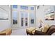 Bright living room with wicker seating, high ceilings, and transomed french doors to outdoor balcony at 283 Saint Lucia Dr # 202, Bradenton, FL 34209