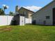 A spacious, green backyard enclosed by a tall, white fence, featuring a handy outdoor storage shed at 30643 Tremont Dr, Wesley Chapel, FL 33543