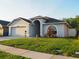 Charming single Gathering home featuring a well-manicured lawn, gray siding, and a two car garage at 30643 Tremont Dr, Wesley Chapel, FL 33543