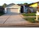 Charming single Gathering home featuring a well-manicured lawn, gray siding, and a two car garage at 30643 Tremont Dr, Wesley Chapel, FL 33543