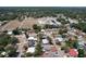 Aerial view of a home in a neighborhood with mature trees, a school, and a pool at 505 Hedge Row Rd, Brandon, FL 33510
