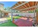 Inviting backyard with a covered wooden deck, artificial grass, and a cozy seating area at 505 Hedge Row Rd, Brandon, FL 33510