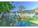 Backyard featuring artificial turf and a playset surrounded by mature landscaping at 505 Hedge Row Rd, Brandon, FL 33510