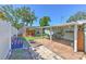 Spacious backyard featuring a brick paver patio, wooden deck, artificial turf, and mature trees at 505 Hedge Row Rd, Brandon, FL 33510