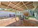 Backyard patio with a metal roof cover, brick pavers, a seating area, and a white fence at 505 Hedge Row Rd, Brandon, FL 33510