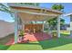Charming backyard featuring a wooden deck under a gazebo, complemented by artificial turf and outdoor toys at 505 Hedge Row Rd, Brandon, FL 33510
