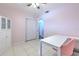 Bright bedroom with a white table, pink chair, and tile floors. A large white storage cabinet is also present at 505 Hedge Row Rd, Brandon, FL 33510
