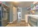 Functional laundry room features a gray refrigerator, washer/dryer, and access to a bedroom with purple bed at 505 Hedge Row Rd, Brandon, FL 33510