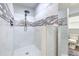 White tiled shower with rainfall showerhead and decorative tiled accent at 505 Hedge Row Rd, Brandon, FL 33510