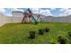 Large backyard featuring lush green grass and a wooden playset, ideal for Gathering fun at 34327 Verbena St, Wesley Chapel, FL 33545