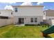 View of the backyard featuring a small patio, lawn, and a home with neutral colored siding at 34327 Verbena St, Wesley Chapel, FL 33545
