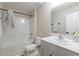 Well-lit bathroom featuring a shower-tub combo with a white countertop, mirror, and black hardware at 34327 Verbena St, Wesley Chapel, FL 33545