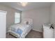 Cozy bedroom featuring a bed with patterned bedding, a dresser, and a window at 34327 Verbena St, Wesley Chapel, FL 33545