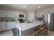 Open kitchen with large island, stainless steel appliances, and light gray cabinets at 34327 Verbena St, Wesley Chapel, FL 33545