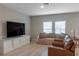 Cozy living room with wood-look floors, a plush sofa, and large television at 34327 Verbena St, Wesley Chapel, FL 33545