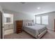 Bright main bedroom showcasing plush carpeting, a tufted headboard and access to the bathroom at 34327 Verbena St, Wesley Chapel, FL 33545