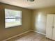 Bright bedroom features tile flooring, a closet, and a large window overlooking the backyard at 4213 Temple Heights Rd, Tampa, FL 33617