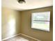 This is a small bedroom with tile flooring and a window overlooking the backyard at 4213 Temple Heights Rd, Tampa, FL 33617
