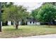 Ranch home featuring a covered entryway and a large front yard with mature trees offering plenty of shade at 4213 Temple Heights Rd, Tampa, FL 33617