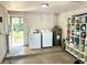 Laundry room including washer, dryer, water heater, utility sink, and storage shelves at 4213 Temple Heights Rd, Tampa, FL 33617