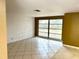 Living room featuring tile floors, a large window, and a white brick accent wall at 4213 Temple Heights Rd, Tampa, FL 33617
