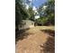 A view of the home's expansive backyard with mature trees and dry lawn at 4617 John Bell Jr Dr, Tampa, FL 33610