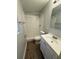 Bathroom featuring white tiled shower, vanity with cabinet and wood look floors at 4617 John Bell Jr Dr, Tampa, FL 33610