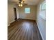 Bedroom features hardwood floors, ceiling fan, window, and walk-in closet at 4617 John Bell Jr Dr, Tampa, FL 33610