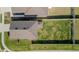 An aerial view focuses on the home's roof and the lush green lawn enclosed by a white fence at 6438 Milestone Loop, Palmetto, FL 34221