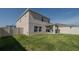 A house's rear view shows the backyard, exterior, patio, vinyl fence, and landscaped lawn at 6438 Milestone Loop, Palmetto, FL 34221
