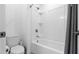Clean bathroom featuring a shower-tub combo, toilet, and white tiled walls at 6438 Milestone Loop, Palmetto, FL 34221