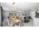 An open-concept dining area boasts a stylish chandelier, wood table, and seamless transition to the living room at 6438 Milestone Loop, Palmetto, FL 34221