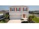 Charming two-story home with neutral siding, red shutters, a welcoming front door, and a well-maintained lawn at 6438 Milestone Loop, Palmetto, FL 34221