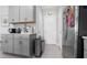 Functional kitchen space with grey cabinets, stainless steel refrigerator, and a view of the pantry door at 6438 Milestone Loop, Palmetto, FL 34221