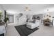 Open-concept living room showcases a modern sectional, tile floors, and seamless flow into the kitchen and dining area at 6438 Milestone Loop, Palmetto, FL 34221