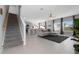 Open-concept living space with modern furnishings, tile floors, a staircase, and access to the kitchen at 6438 Milestone Loop, Palmetto, FL 34221