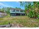 Exterior of the home from the backyard, featuring covered parking and a large backyard at 9503 Alice Ln, Riverview, FL 33578