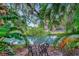 Beautiful outdoor view of the canal with tropical foliage, a wrought iron table, and chairs at 9503 Alice Ln, Riverview, FL 33578