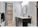 Updated bathroom with a modern vanity, decorative mirror, and a walk-in shower with tile surround at 9503 Alice Ln, Riverview, FL 33578