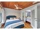 Bedroom features a blue accent bed, wood ceiling, and access to a second bedroom at 9503 Alice Ln, Riverview, FL 33578