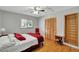 Cozy bedroom featuring hardwood floors, a ceiling fan, and natural light from a window at 9503 Alice Ln, Riverview, FL 33578